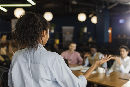 vista-traseira-de-uma-mulher-fazendo-uma-reuniao-no-trabalho-com-colegas